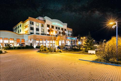 ein Hotel in der Nacht mit Parkplatz davor in der Unterkunft Hotel Savannah in Chvalovice