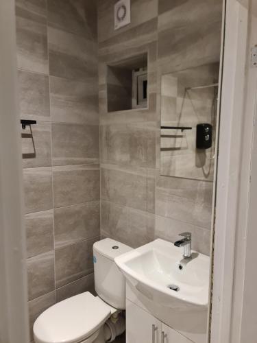 a bathroom with a white toilet and a sink at Self contained studio flat in Luton -Close to luton airport - Luton Dunstable Hospital - Business contractors - Family - All welcome -Short or Long Stay in Luton