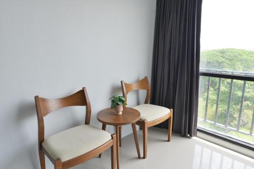 two chairs and a table in a room with a window at VST Residence -SHA PLUS Certified in Ban Khlong Bang Ping