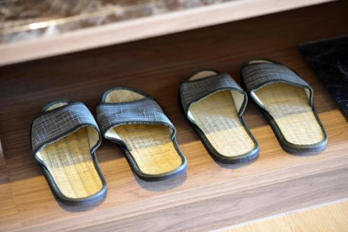 a group of four pairs of slippers on a shelf at VST Residence -SHA PLUS Certified in Ban Khlong Bang Ping
