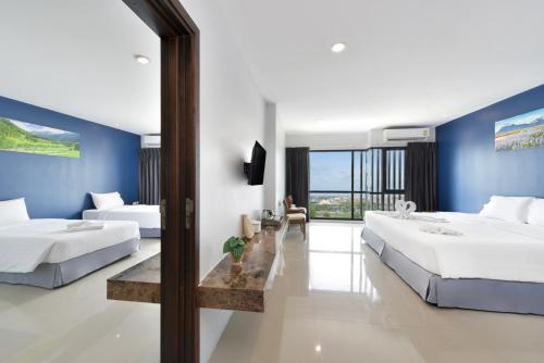 two beds in a room with blue walls at VST Residence -SHA PLUS Certified in Ban Khlong Bang Ping