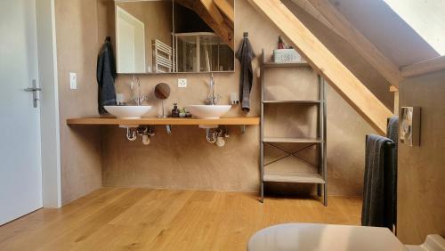 uma casa de banho com dois lavatórios num quarto em Niesen Loft em Spiez