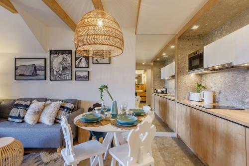 a kitchen and living room with a table and a couch at Apartament RELAKS - komfortowy apartament z bezpłatnym jacuzzi, sauną oraz podziemnym parkingiem w cenie in Zakopane
