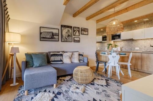 uma sala de estar com um sofá e uma mesa em Apartament RELAKS - komfortowy apartament z bezpłatnym jacuzzi, sauną oraz podziemnym parkingiem w cenie em Zakopane