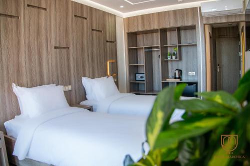 2 camas en una habitación de hotel con almohadas blancas en Marchica Hotel, en Nador