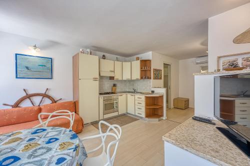 a kitchen and a living room with a table at Astra 1 Veli Lošinj Harbour View - Happy Rentals in Veli Lošinj