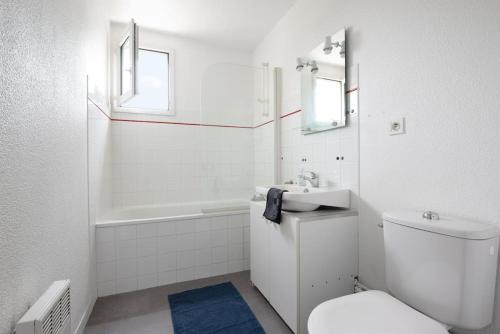 een witte badkamer met een toilet en een wastafel bij T2 Rangueil - Terrasse + 2 Parkings - 4 personnes in Toulouse