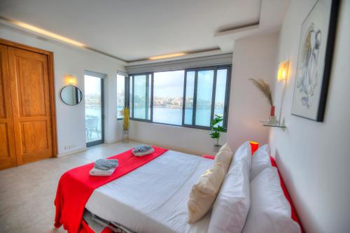 スリーマにあるSpacious 3bedrooms with spectacular views GOSLM-6の赤い毛布が掛けられた大きなベッドのある寝室