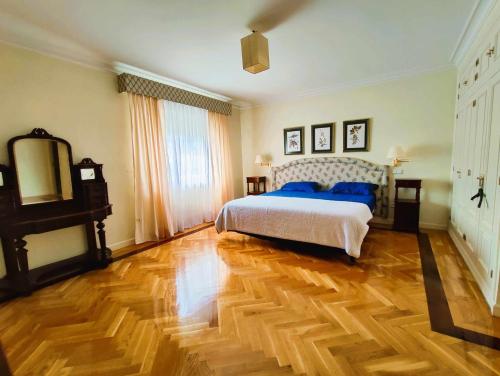 um quarto com uma cama e piso em madeira em La Casona Imperial em Alpedrete