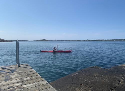 a person in a red boat on a lake at Hamnhuset Björkö in Björkö