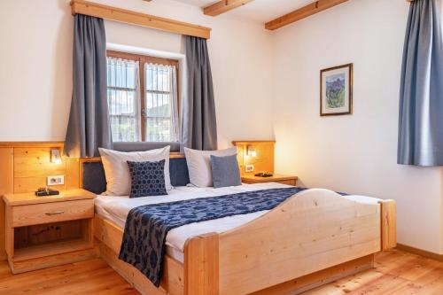 ein Schlafzimmer mit einem Holzbett und einem Fenster in der Unterkunft Schreiberhof Landhaus in Lajen