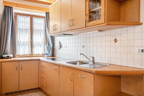 a kitchen with wooden cabinets and a sink at Schreiberhof Landhaus in Laion