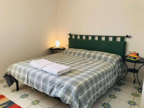 a bedroom with a bed with a plaid blanket at Villa San Sisinnio Argegno in Argegno
