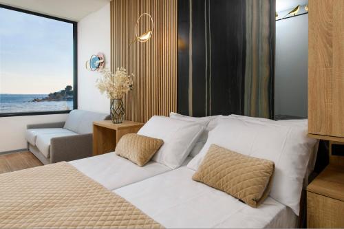 a bedroom with a white bed and a living room at Via Mare Luxury Rooms in Split
