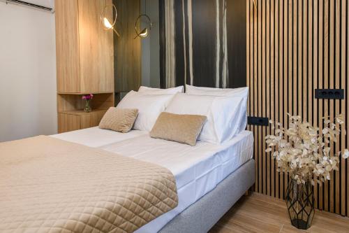 a bedroom with a large bed with white sheets and pillows at Via Mare Luxury Rooms in Split