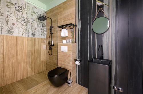a bathroom with a black toilet and a mirror at Via Mare Luxury Rooms in Split