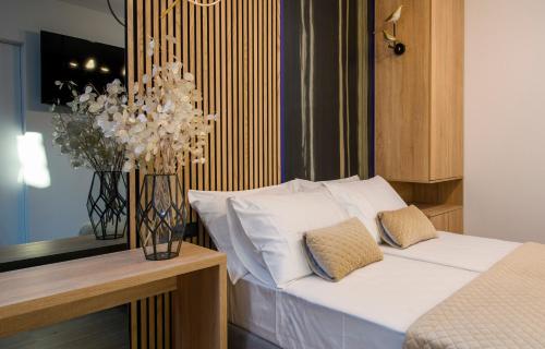 a bedroom with a bed and a vase with flowers at Via Mare Luxury Rooms in Split
