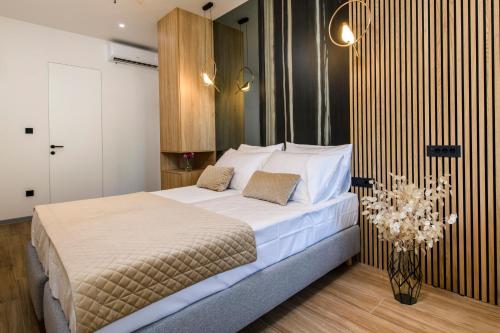 a bedroom with a large bed with white sheets at Via Mare Luxury Rooms in Split