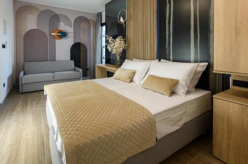 a bedroom with a large bed and a chair at Via Mare Luxury Rooms in Split