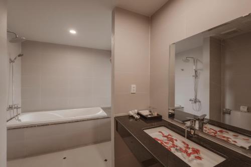W łazience znajduje się umywalka, wanna i lustro. w obiekcie Praha Hotel w Duong Dong