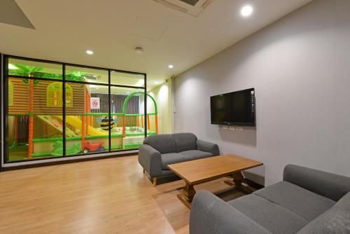 a living room with two chairs and a table and a tv at VST Residence -SHA PLUS Certified in Ban Khlong Bang Ping