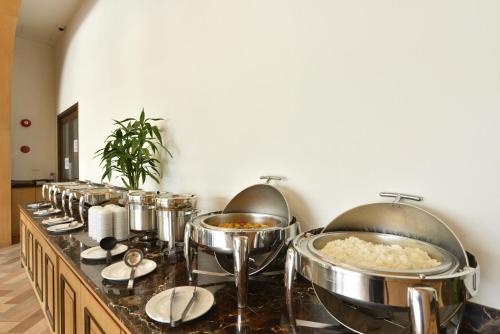 a buffet with several large metal bowls of food at VST Residence -SHA PLUS Certified in Ban Khlong Bang Ping