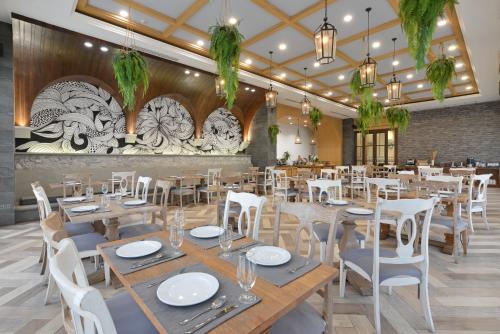 a dining room with tables and white chairs at VST Residence -SHA PLUS Certified in Ban Khlong Bang Ping