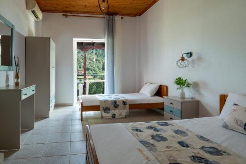 a bedroom with two beds and a kitchen with a window at Amo el mar Porto Koufo in Porto Koufo