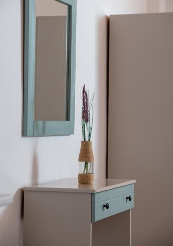 a table with a mirror and a plant on it at Amo el mar Porto Koufo in Porto Koufo