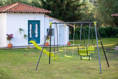 a playground with yellow swings in a yard at Amo el mar Porto Koufo in Porto Koufo