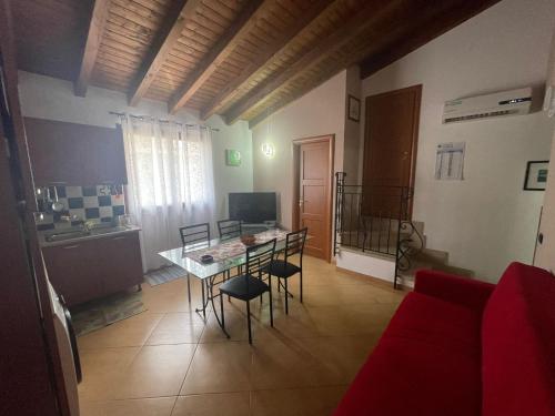 sala de estar con mesa y sofá rojo en SinyHouse, en Terrasini