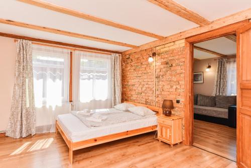 Un dormitorio con una cama y una pared de ladrillo. en Villa Victoria, en Ventspils