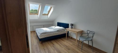Villa Nova في Szuminka: غرفة نوم صغيرة مع سرير وطاولة مع كرسي