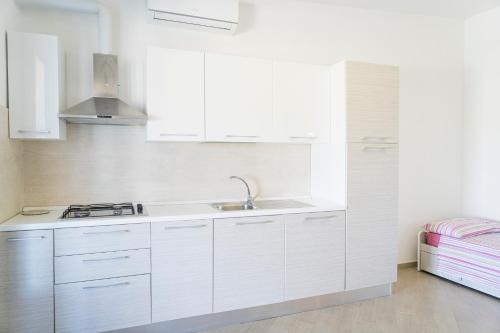 a white kitchen with white cabinets and a sink at Azienda Agrituristica Scalelle in Otranto