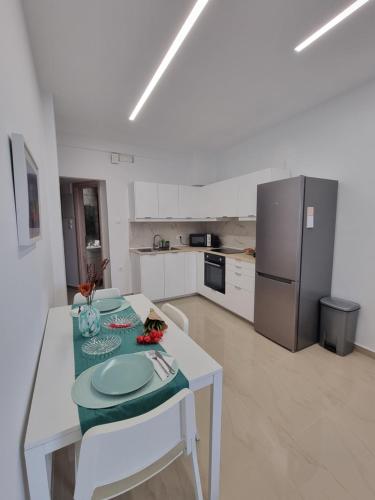 uma cozinha branca com uma mesa e um frigorífico em Danae Luxury Apartment - Rhodes in Ilha de Rhodes