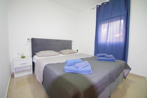 a bedroom with a bed with blue towels on it at Apartment Pineta in village Valbandon in Valbandon