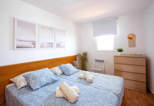 a bedroom with a blue bed with two towels on it at Apartamento Maypa 5 Mar in Meloneras