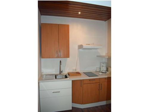 a kitchen with wooden cabinets and a sink at Kandelbleibe in Waldkirch