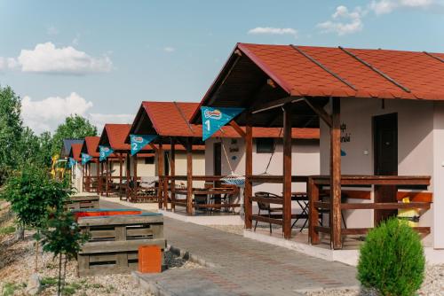 szereg restauracji z drewnianymi stołami i ławkami w obiekcie COMPLEX AGREMENT BELLAVI w mieście Ocna Mureş