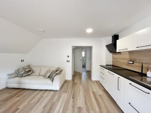 a living room with a white couch in a kitchen at Hiša Grilc in Kranjska Gora
