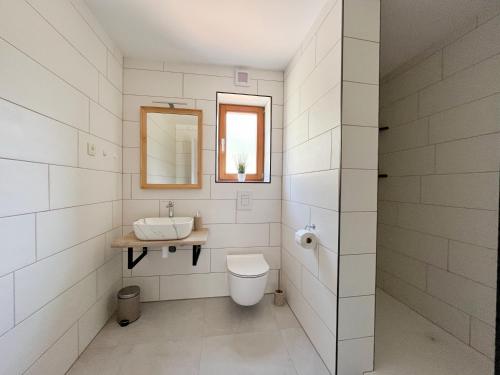 a white bathroom with a sink and a toilet at Hiša Grilc in Kranjska Gora