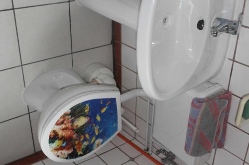 クラーコー・アム・ゼーにあるFerienquartiere Roloffのバスルーム(シートに絵画が飾られたトイレ付)