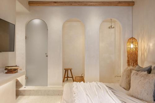 a bedroom with a bed and three arched windows at Stoa Suites in Naxos Chora