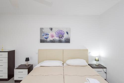 een slaapkamer met een bed en twee nachtkastjes bij Lightbooking Sun Club deluxe Playa del Ingles in Playa del Inglés