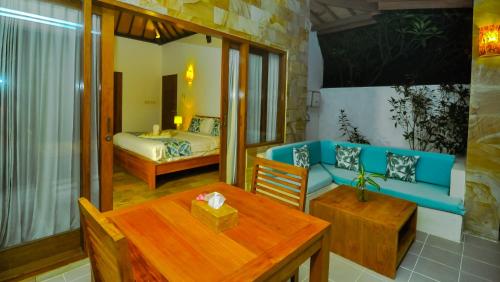 a living room with a table and a couch and a bed at The Haven in Gili Trawangan