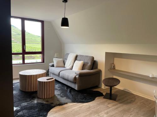 a living room with a couch and two tables at Appartements de Manon au cœur des vignes in Kientzheim