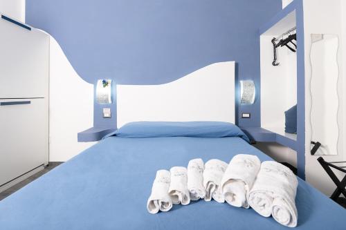 a blue bed with white towels on top of it at La Magnolia Rooms in Procida