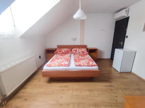 a bedroom with a large bed in a attic at Viktória Panzió Zamárdi in Zamárdi