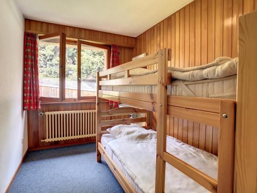 ヴェルビエにあるVouamons A4の木製の壁の客室で、二段ベッド2組が備わります。