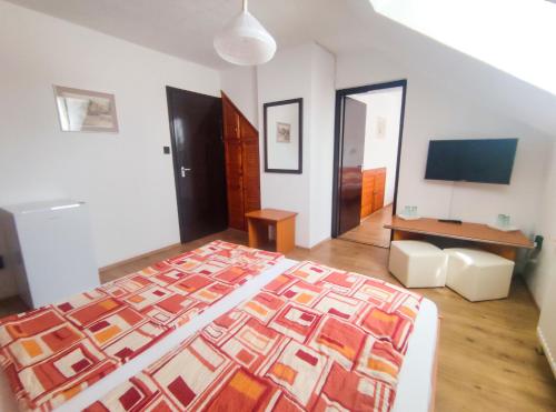 a bedroom with a large bed and a television at Viktória Panzió Zamárdi in Zamárdi
